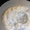 dusting gluten free pecan snowballs in powdered sugar