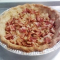 cooked bacon and onion in the bottom of the cooked gluten free pie shell